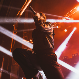 Loz Taylor performing live in London surrounded by red and white lights